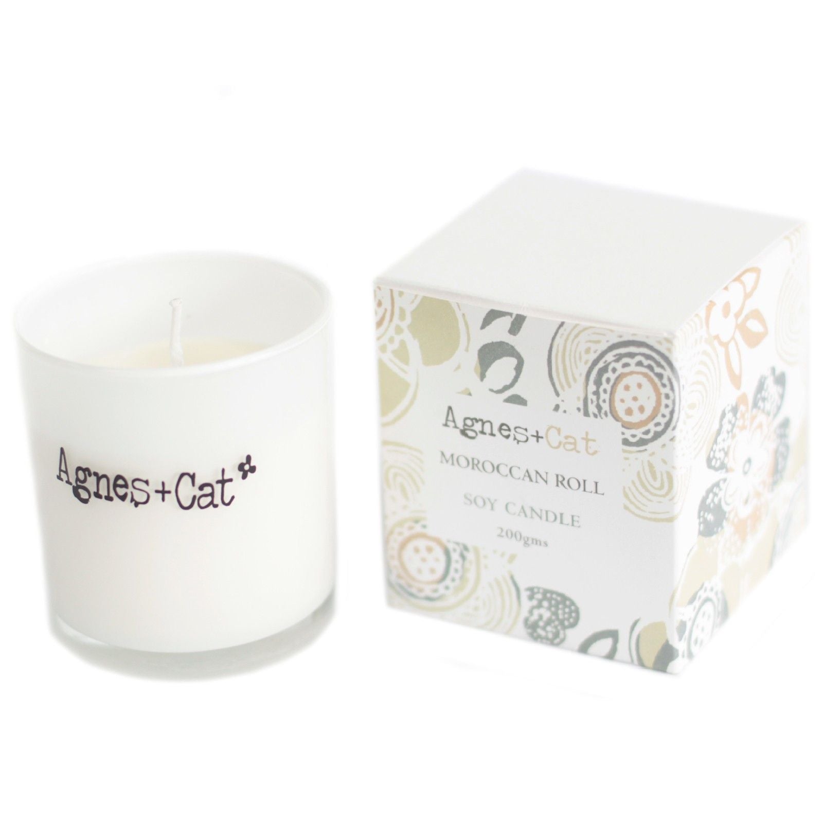 Small cream-coloured votive candle in a clear glass holder, featuring a simple paper label with black text.