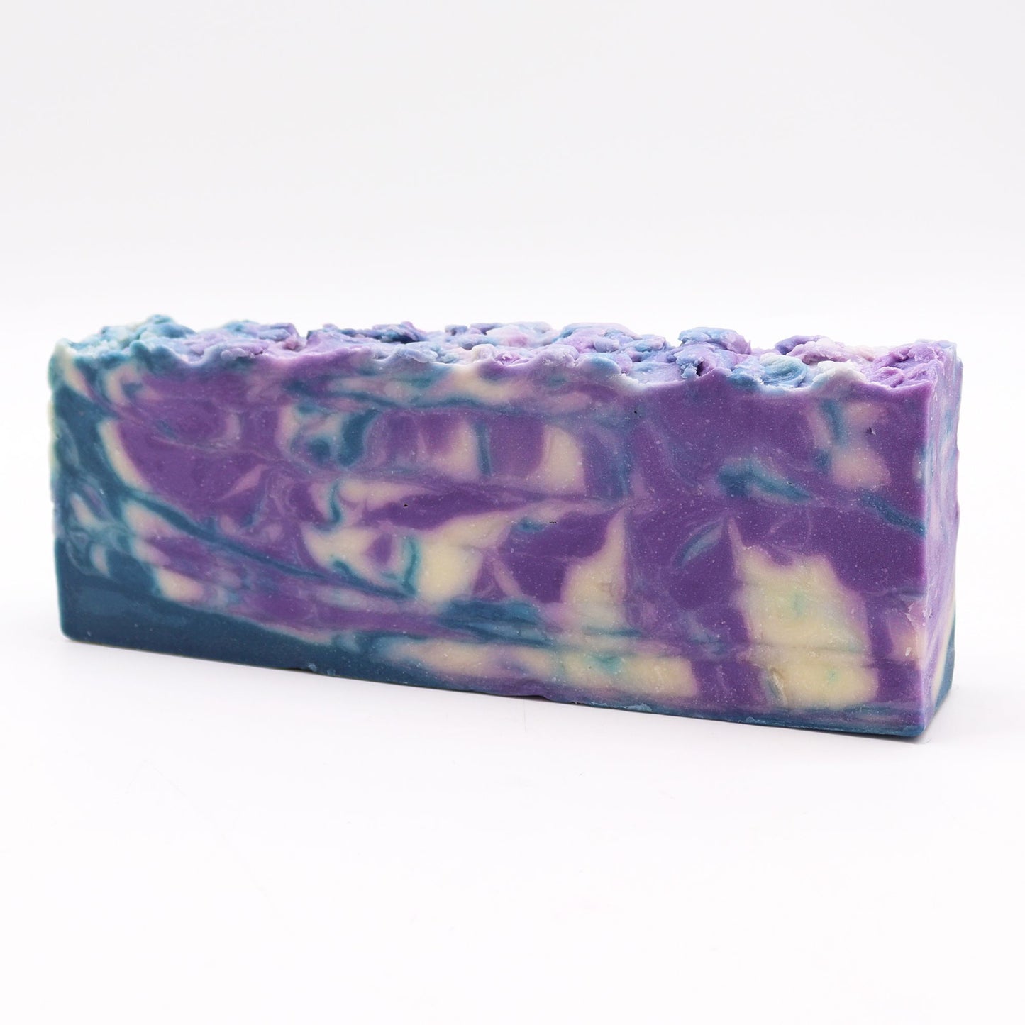 Large rustic loaf of handmade olive oil soap infused with green herbs and natural botanicals.