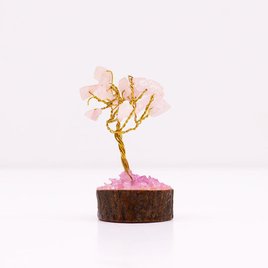 Miniature gemstone tree with delicate pink rose quartz leaves on a natural wood base.