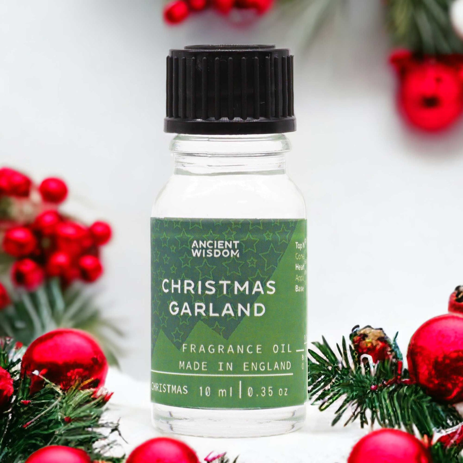A 10ml amber glass bottle of Christmas Garland fragrance oil with a festive label.
