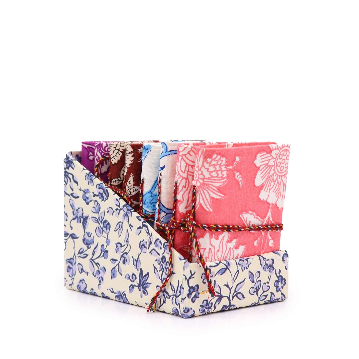 Selection of small, pocket-sized notebooks with various colourful floral patterns and fabric-bound covers.