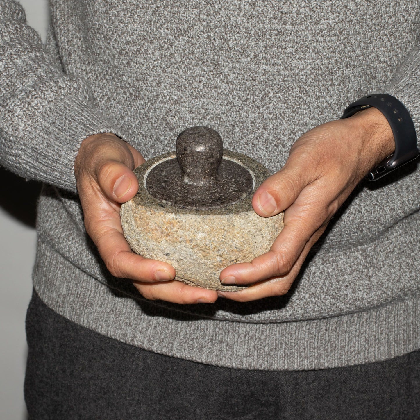 Hand-carved medium-sized natural riverstone pot with a textured grey stone finish and earthy organic shape.