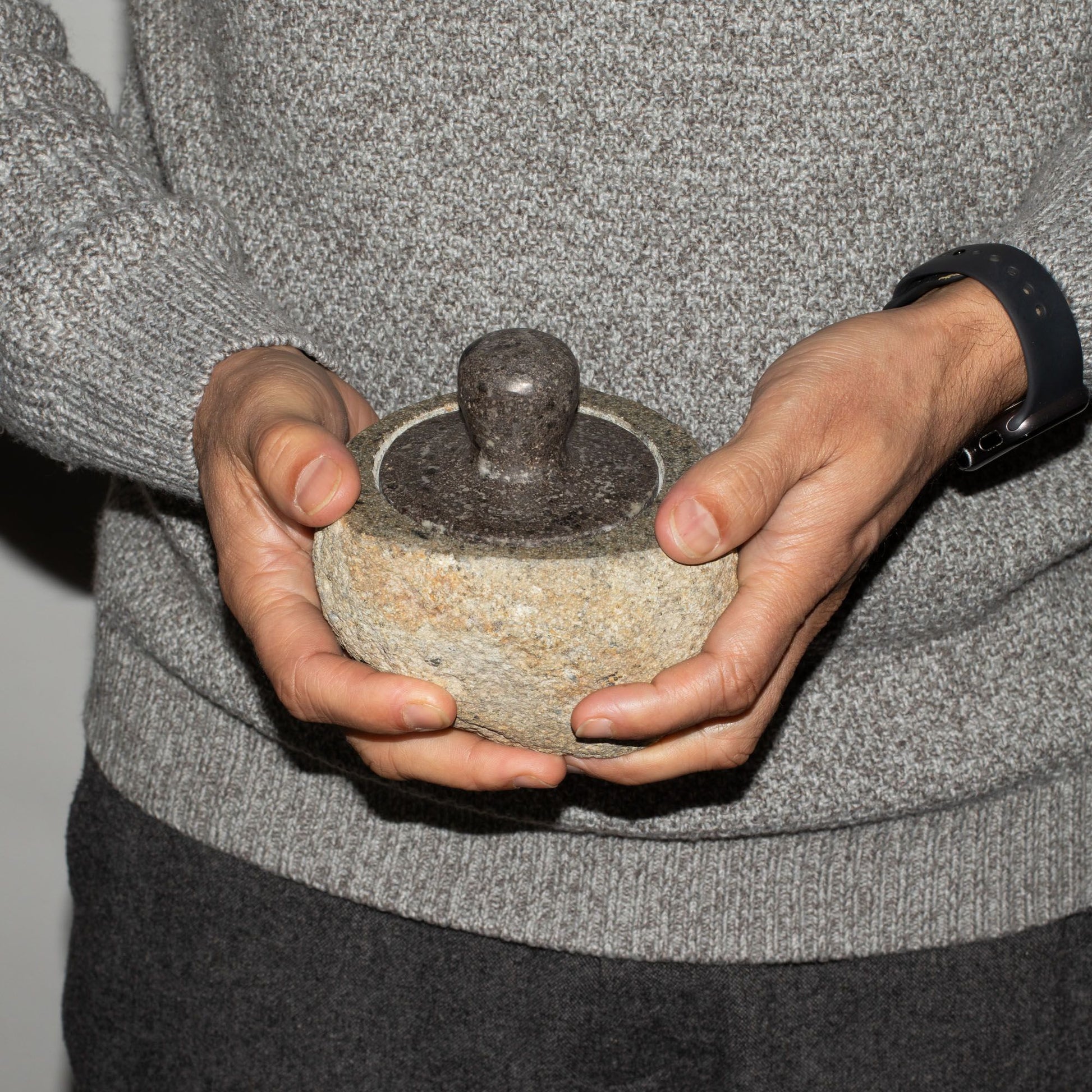 Hand-carved medium-sized natural riverstone pot with a textured grey stone finish and earthy organic shape.