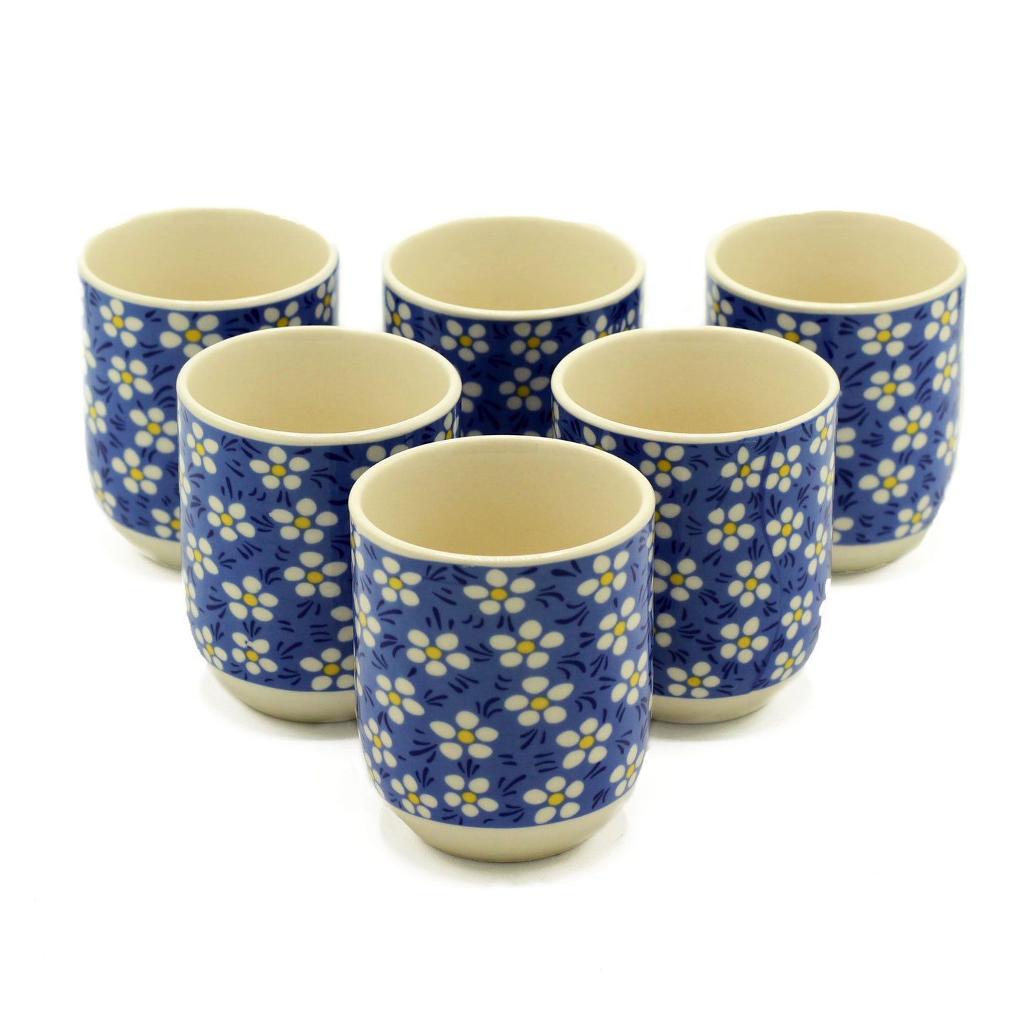 Elegant white ceramic tea cups featuring a delicate blue daisy floral pattern and matching saucers.