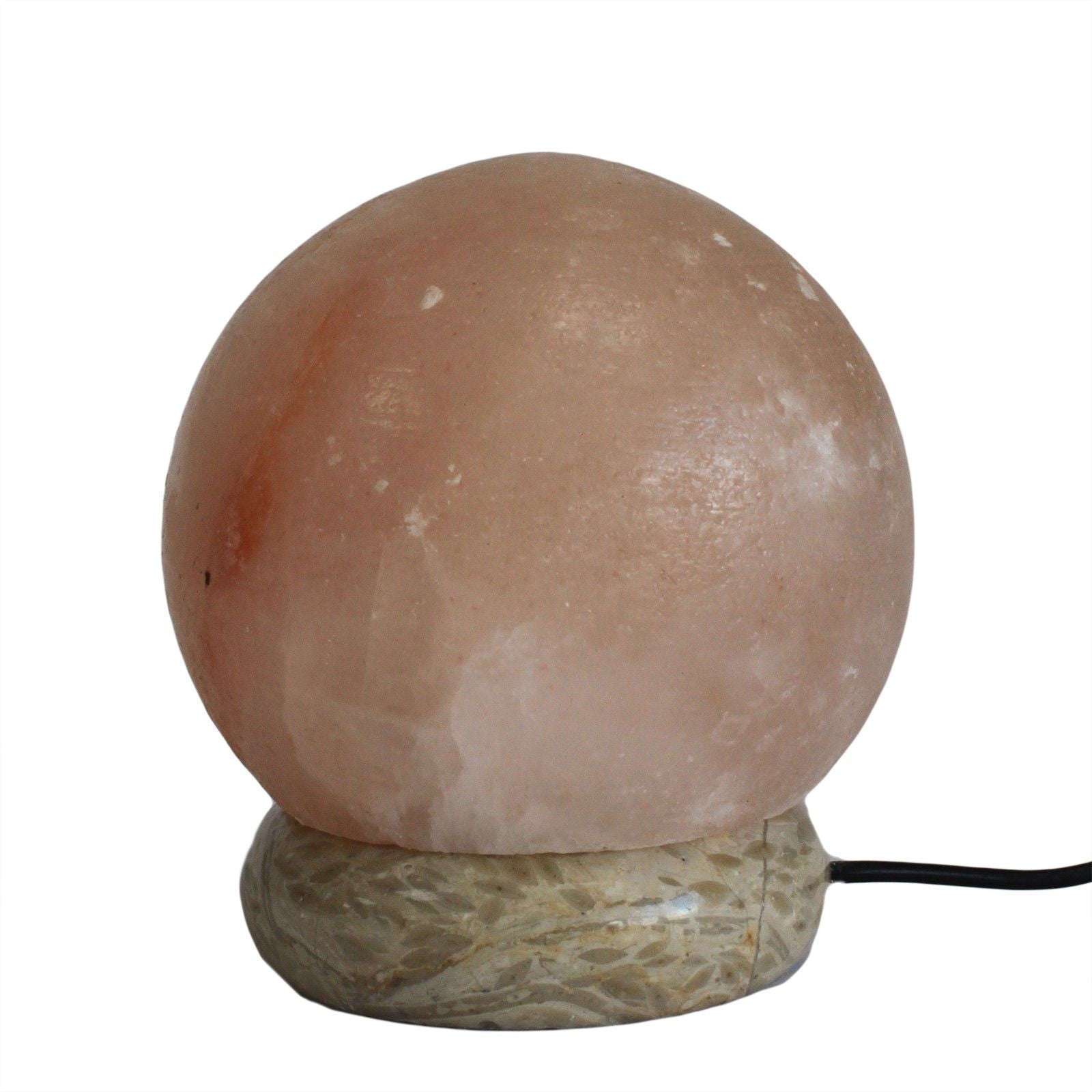 Small spherical pink Himalayan salt lamp glowing softly on a wooden base with a USB power connection.