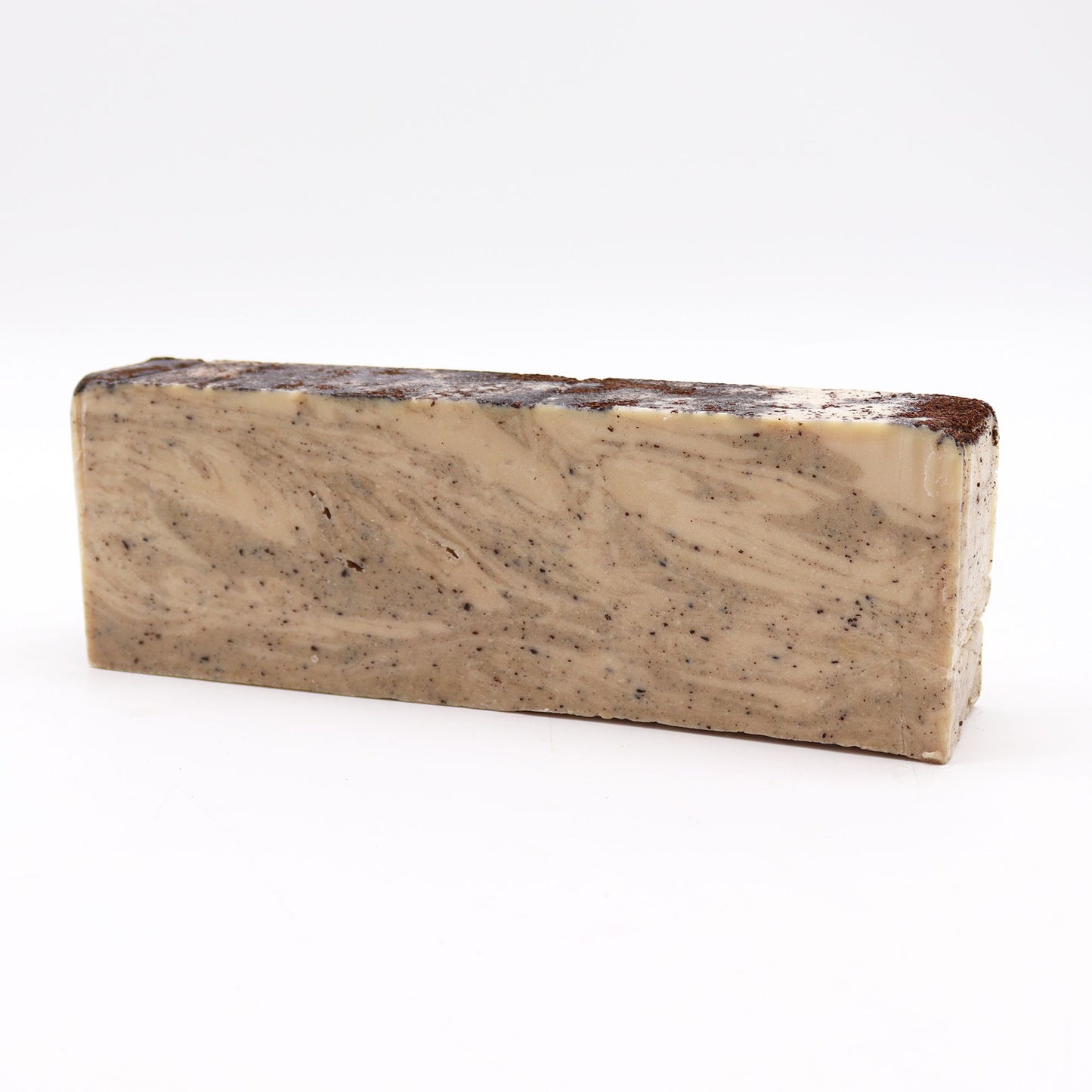 Handcrafted olive oil soap loaf topped with natural coconut fibres for gentle exfoliation.